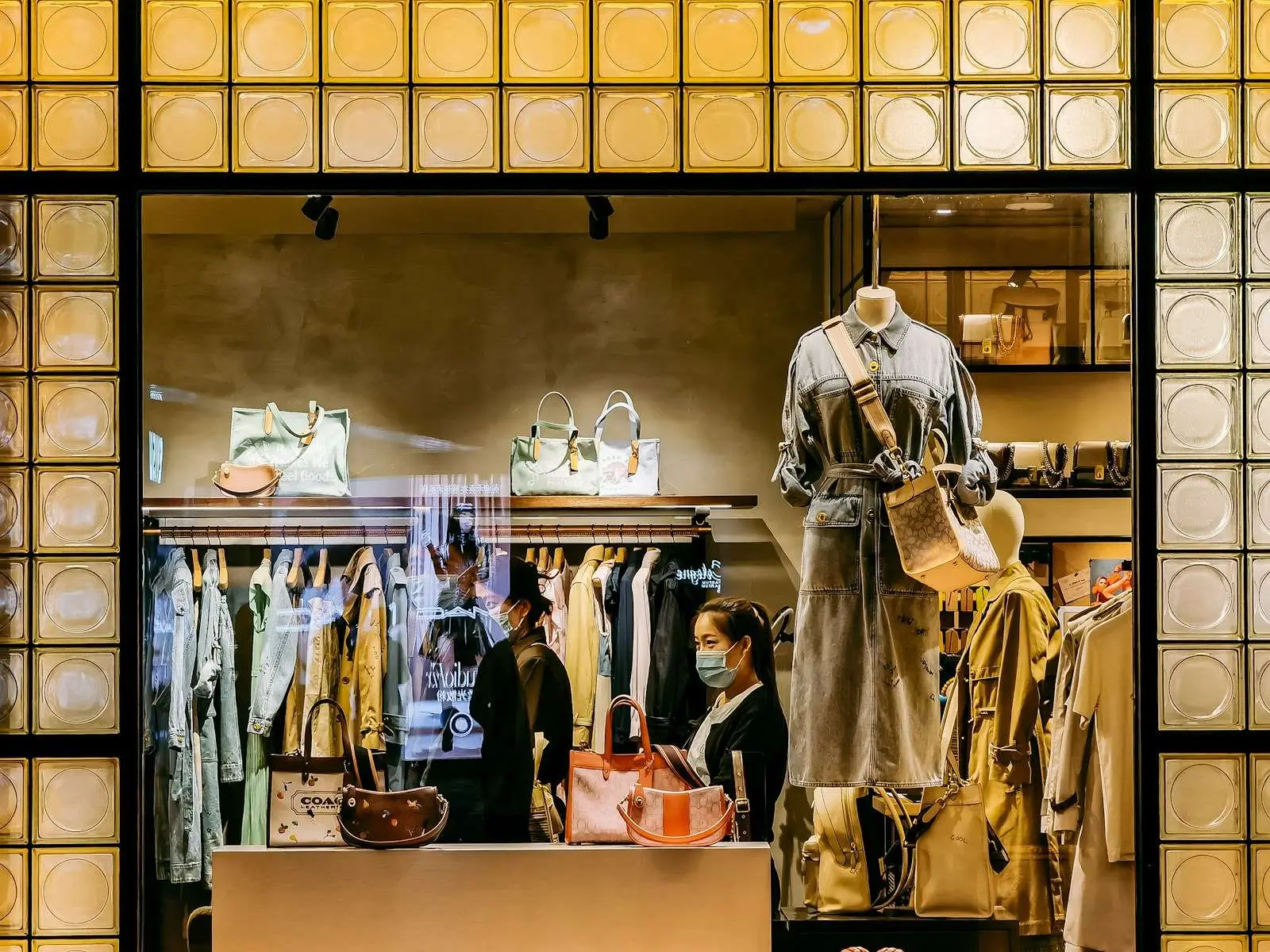 man in beige and brown uniform standing in front of clothes store